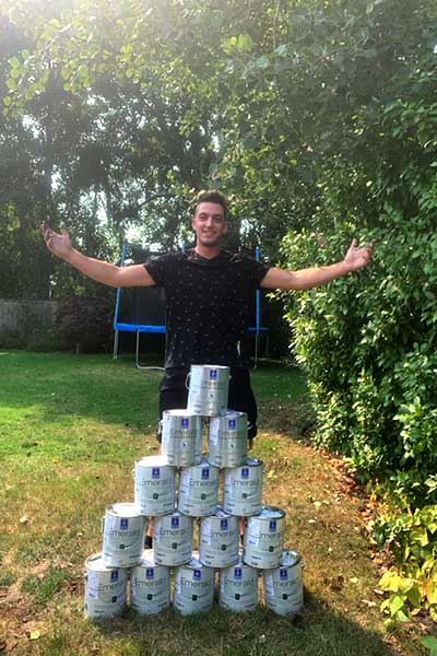 Galen standing by a tower of paint cans
