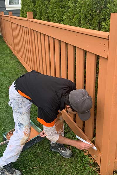 Painter painting a fence